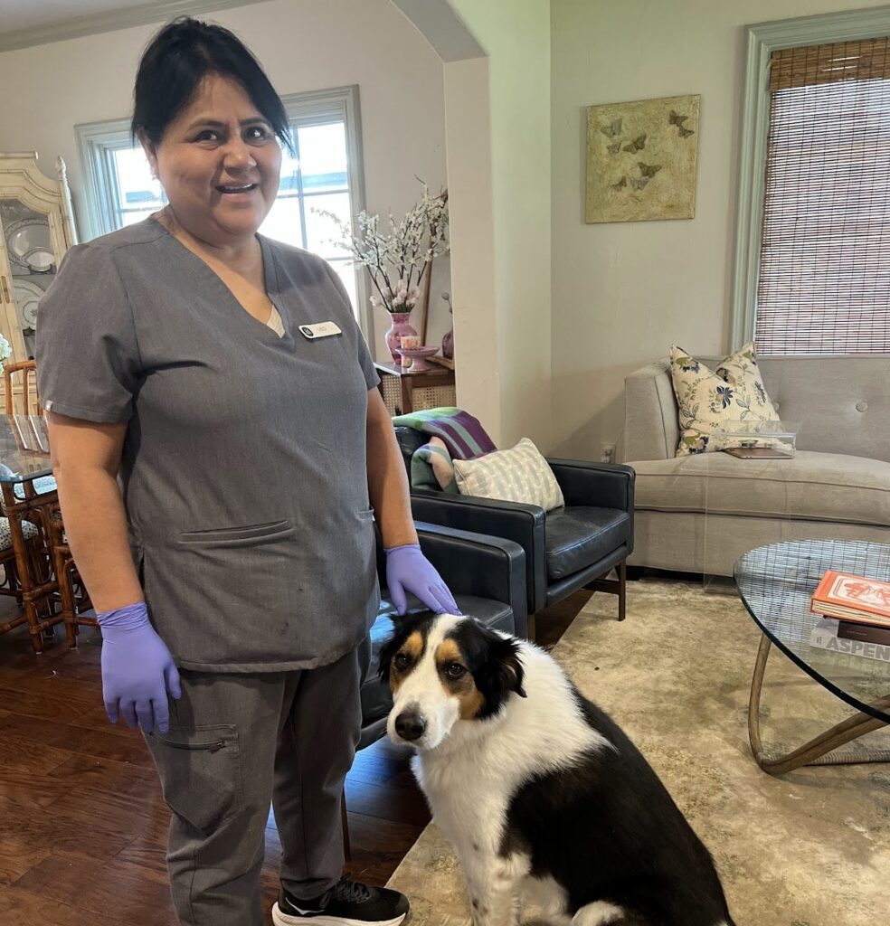 A smiling professional cleaner poses with a dog in a tidy living room A smiling professional cleaner poses with a dog in a tidy living room, showing the comprehensive care involved when you deep clean your kitchen