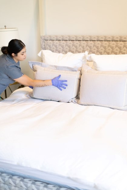 A lady cleaning and making bed. A lady cleaning and making bed. Lady is from Vella cleans.