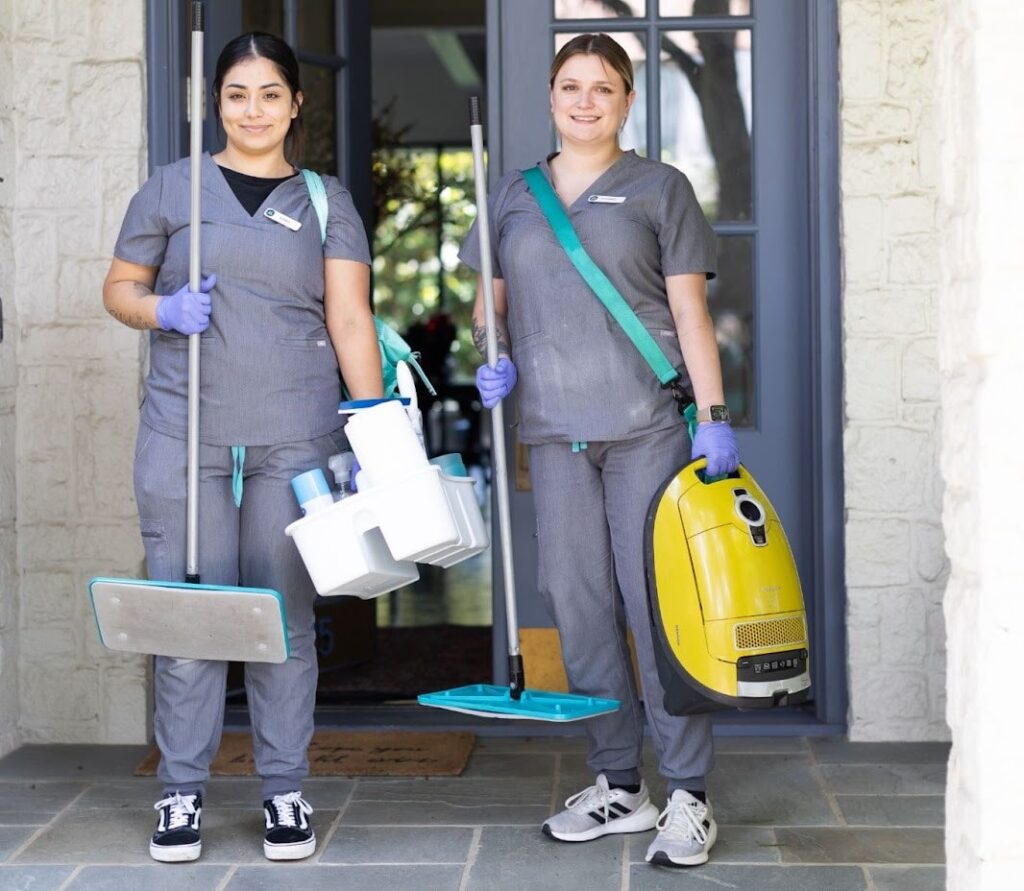 Two cleaners standing with cleaning supplies Two cleaners standing with cleaning supplies, prepared to show how to clean your microwave as part of a professional kitchen cleaning routine.