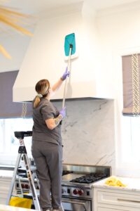 A Vella cleaning staff using a Sh-Mop to clean a kitchen chimney in Dallas.