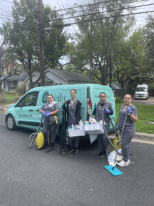 Vella cleaning staff standing by the branded company van with supplies, promoting ethical housekeeping in Dallas, Texas.