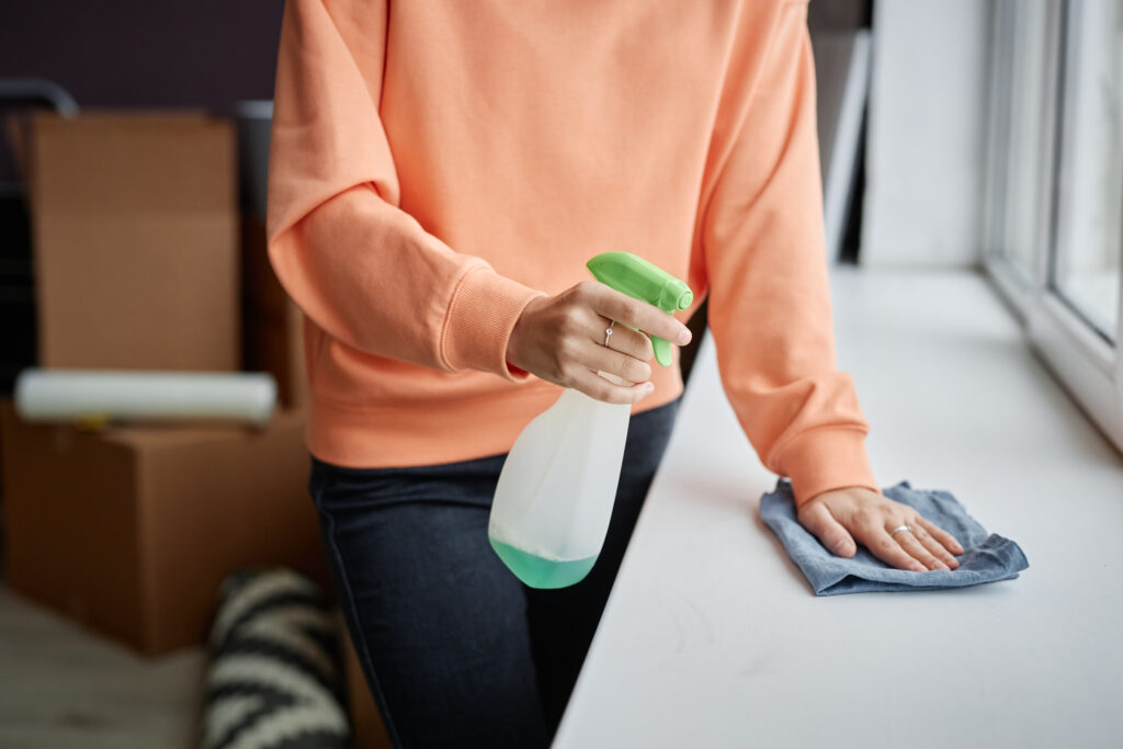 A Vella worker with a cleaning liquid and microfibre cloth to clean the countertop.