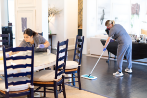 Two Vella cleaners deep cleaning tile floor and dining area in a Dallas home for improved hygiene.