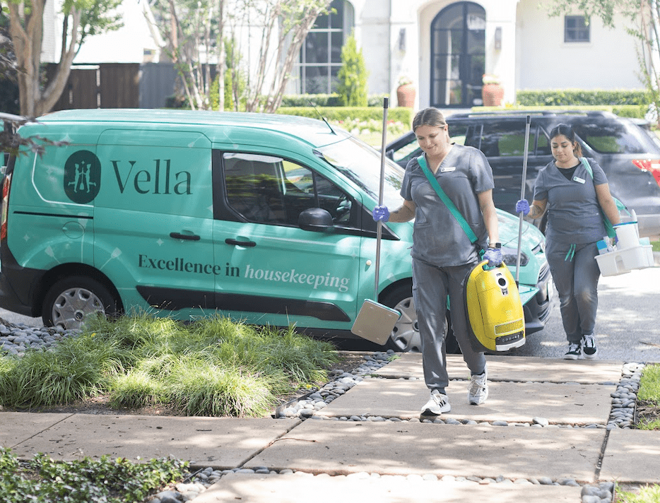 Two of Vella’s staff enter the driveway with cleaning equipment.